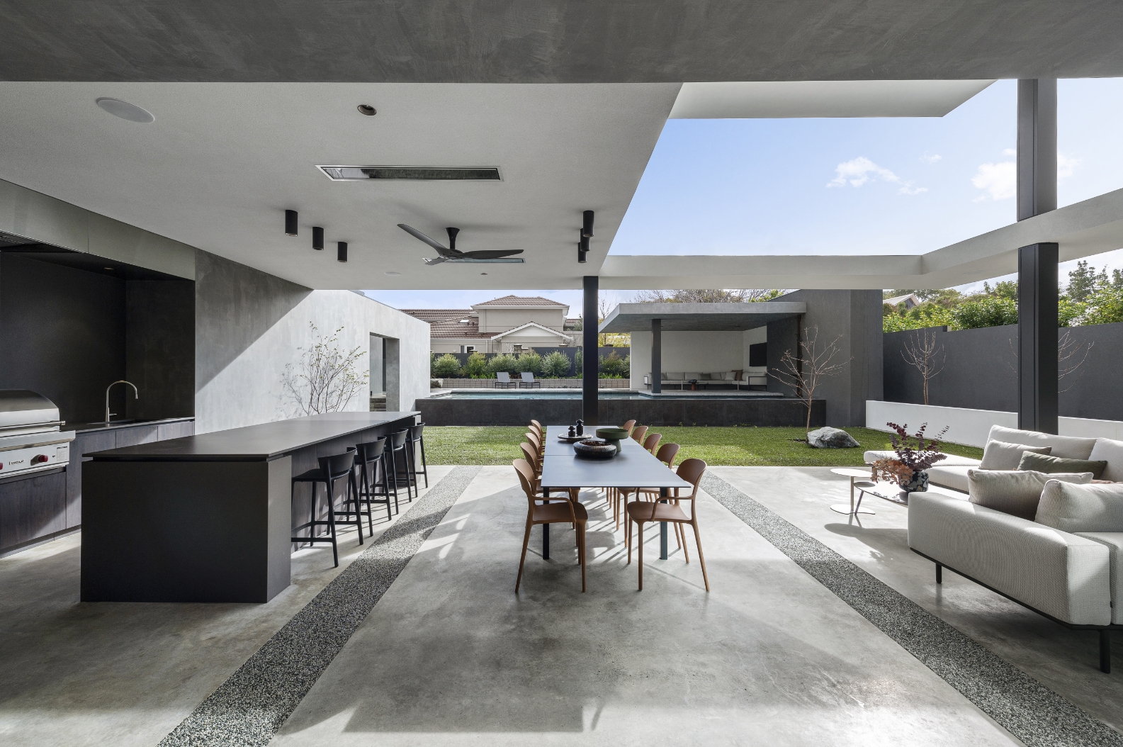 Modern outdoor patio with kitchen and dining area.