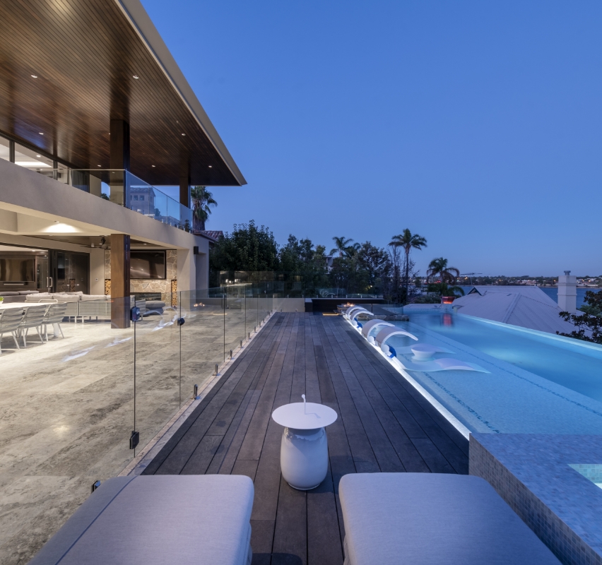Luxury home exterior with infinity pool at dusk