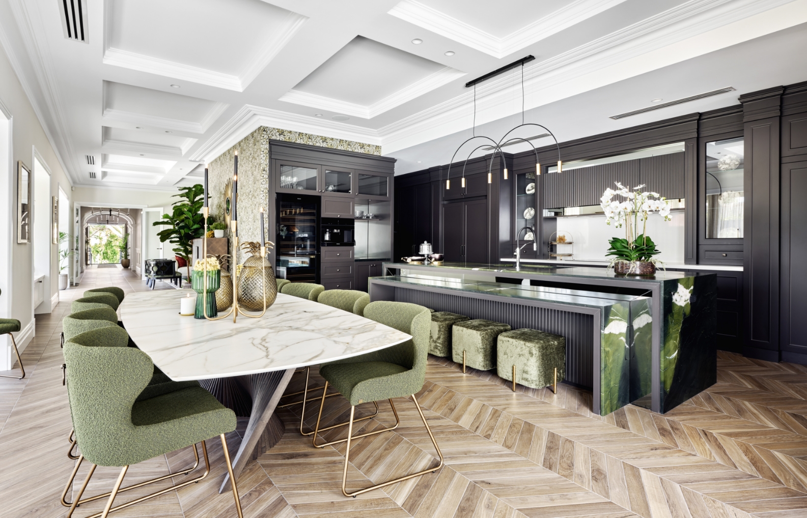 Modern kitchen interior with marble island and green accents.