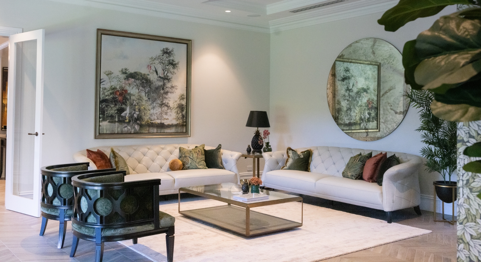 Elegant living room with sofas, art, and decorative plants.