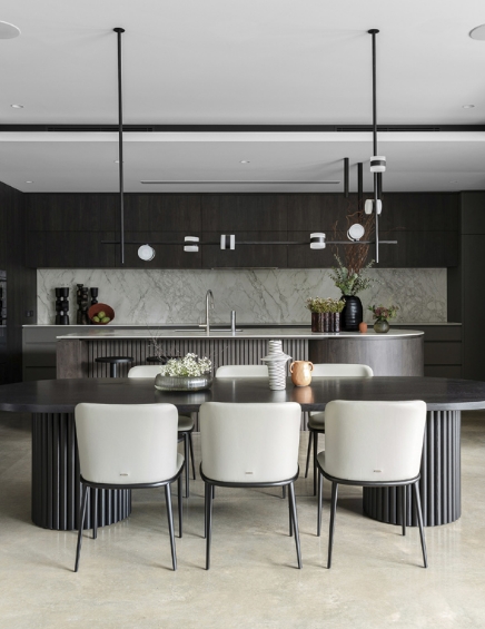 Modern kitchen interior with marble and dark wood elements.